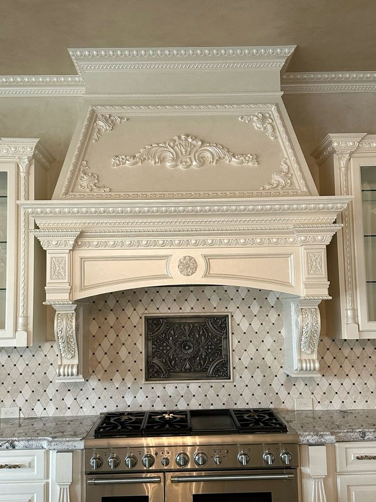 Luxury small kitchen featuring a custom plaster range hood above the cooktop.