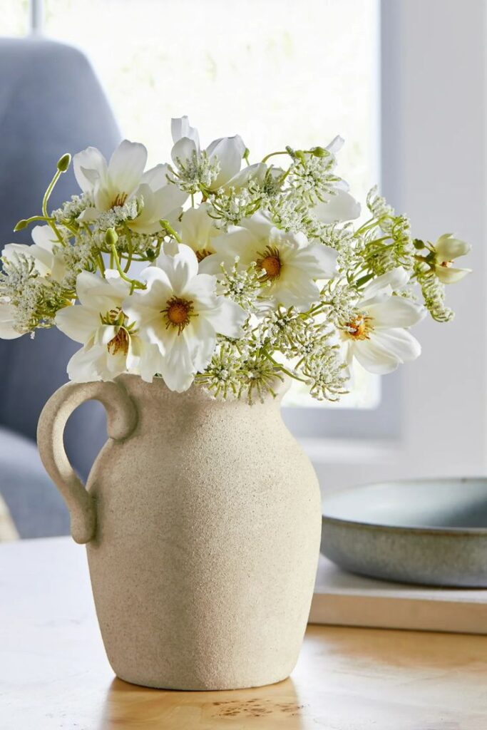 Modern kitchen featuring handcrafted ceramic bowls, pitchers, and decorative vases.