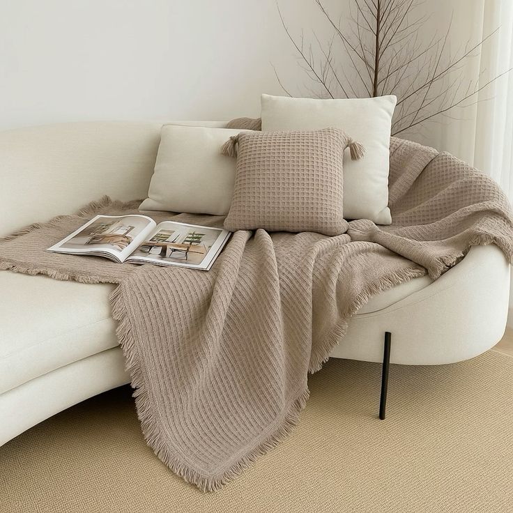 a soft throw blanket casually draped over a neutral sofa for added warmth and texture.
